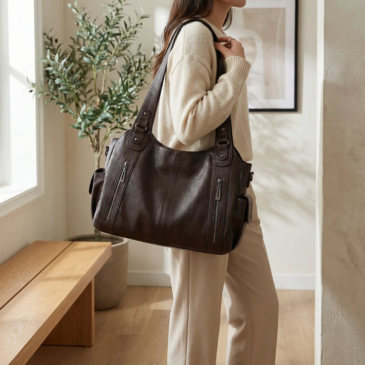 Kobieta nosząca elegancką brązową torbę crossbody Nikita na ramieniu