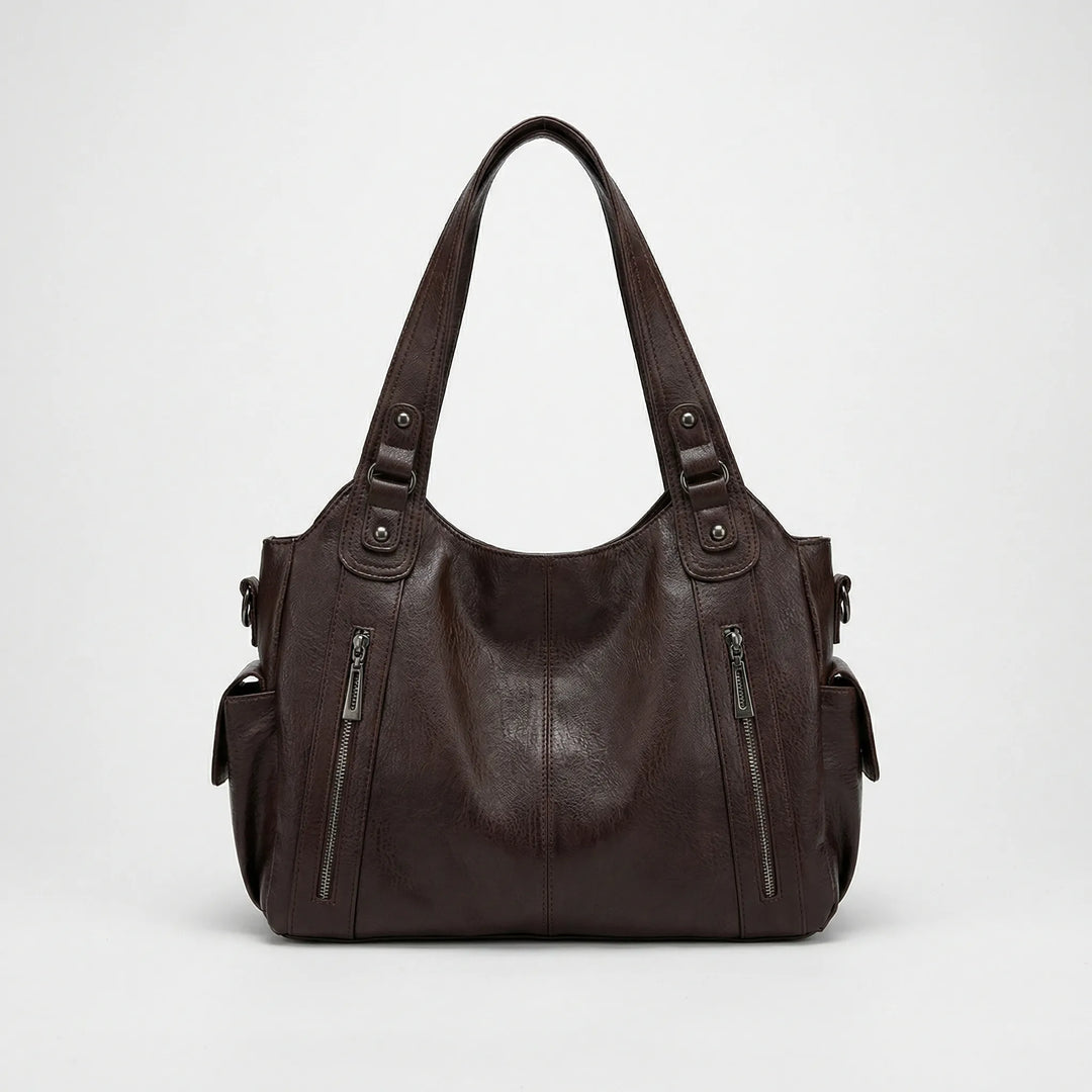 Widok z przodu na brązową torbę crossbody Nikita na jasnym tle
