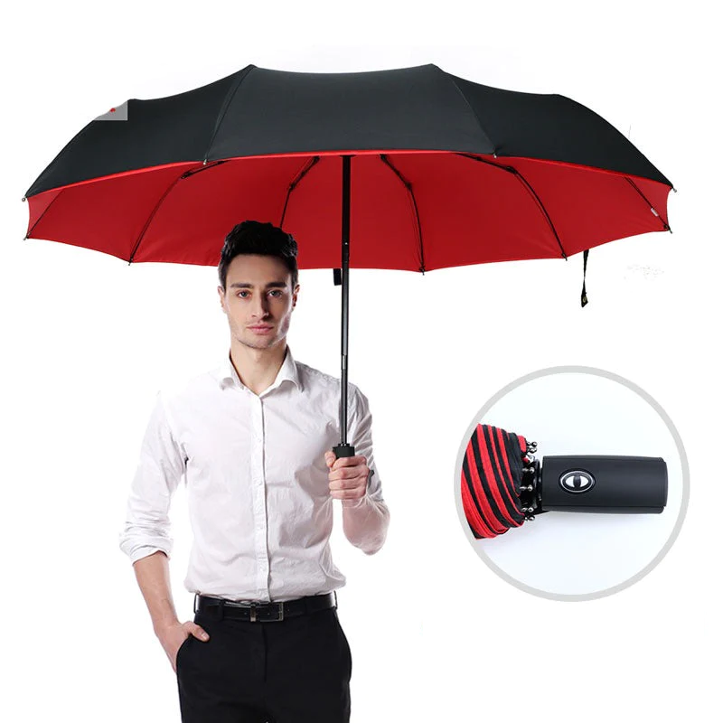 Mężczyzna trzymający czarno-czerwony wiatroszczelny parasol AeroShield
