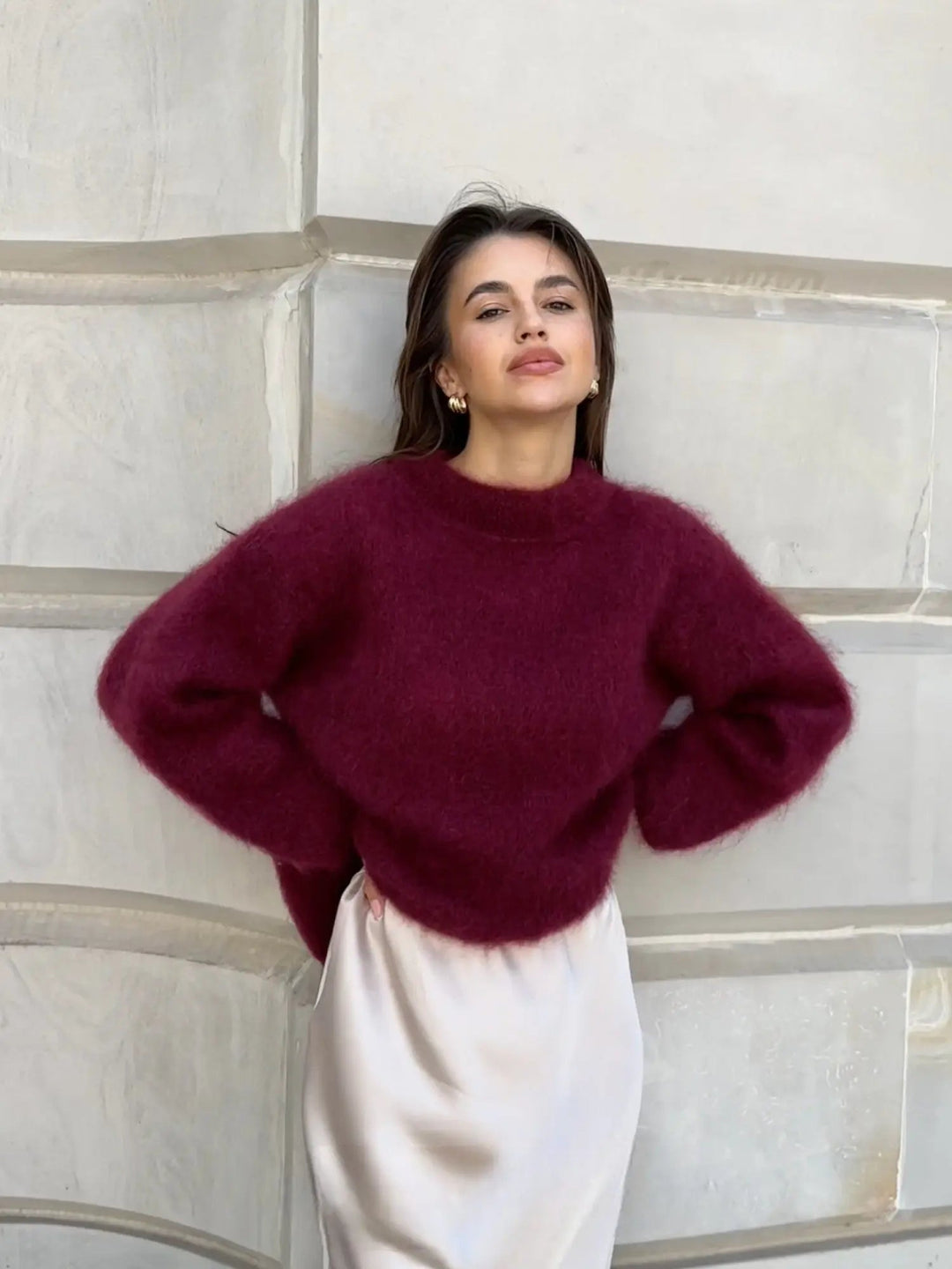 Kobieta w eleganckim bordowym pulowerze oversize