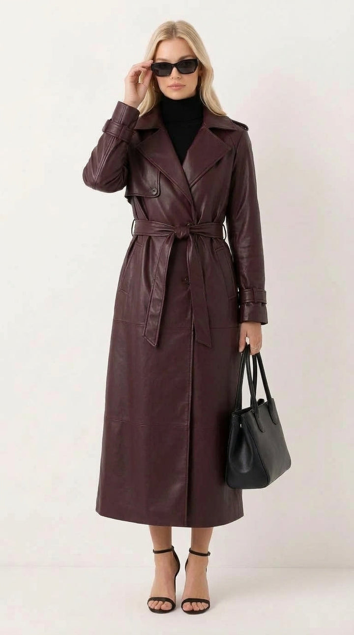 Modelka w eleganckim długim bordowym płaszczu skórzanym z paskiem prezentująca stylizację