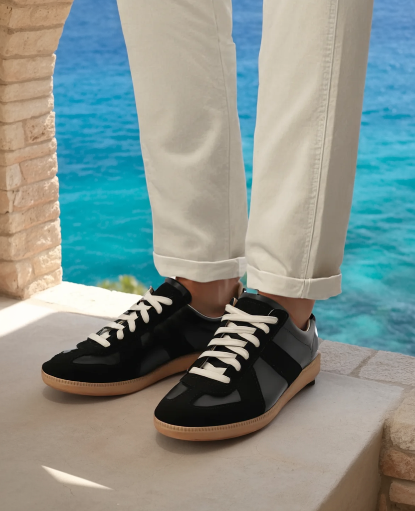 Męskie sneakersy retro prezentowane na stopach z jasnymi spodniami