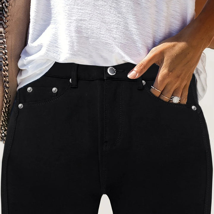Zbliżenie na przednie kieszenie czarnych damskich jeansów skinny z ozdobnymi guzikami
