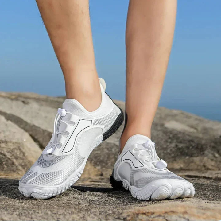Białe oddychające buty do wody na skalistym podłożu