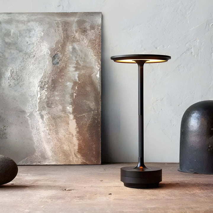 Czarna bezprzewodowa lampa nocna LED stojąca na drewnianym blacie w eleganckim wnętrzu