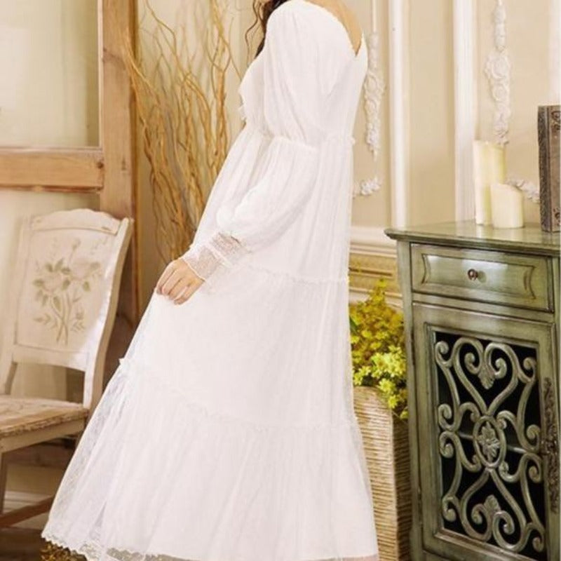 Elegancka biała damska koszula nocna maxi z długim rękawem, koronką i ozdobnymi falbankami.