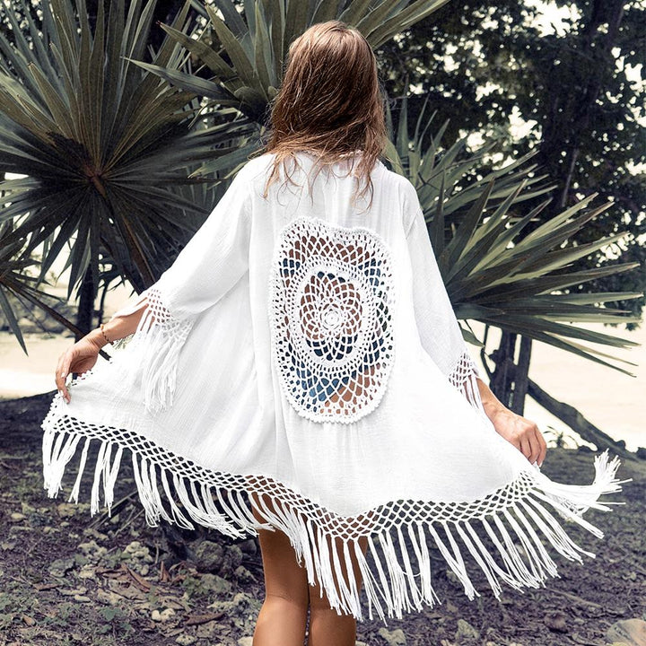 Biała damska narzutka plażowa z frędzlami i ozdobnym wycięciem, idealna na lato i styl boho.