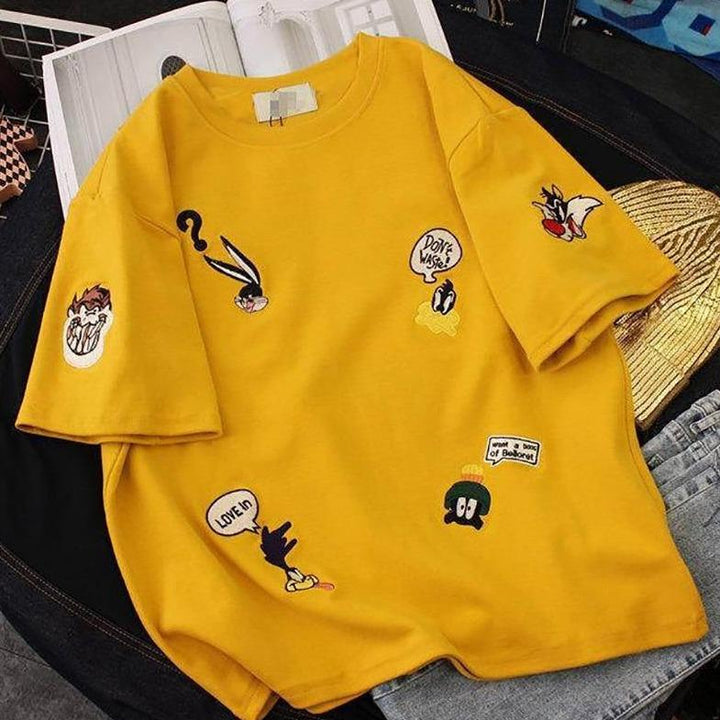 Modna żółta koszulka oversize damska. Casualowy T-shirt z unikatowym bajkowym wzorem. Wygodny, letni fason.