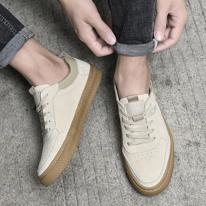 Zbliżenie od góry na beżowe męskie sneakersy Maxon na betonowym podłożu