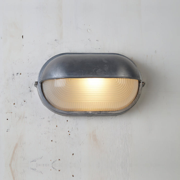 Zielona industrialna lampa ścienna, odporna na warunki, idealna na taras.