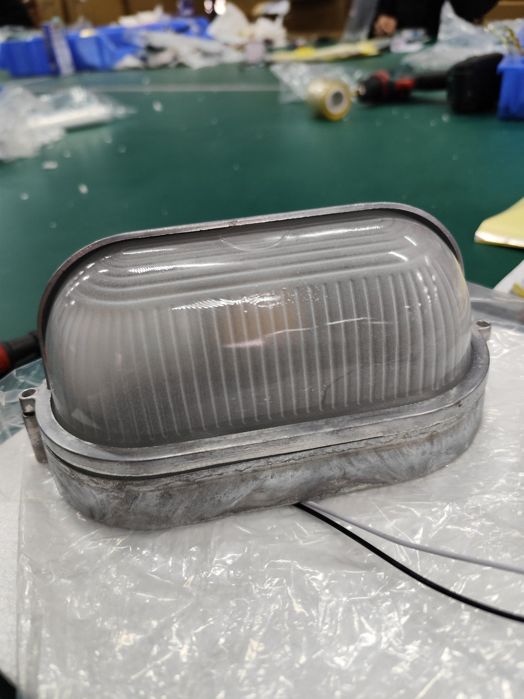 Industrialna zielona lampa zewnętrzna, metalowa, na taras, ze szkłem ryflowanym.