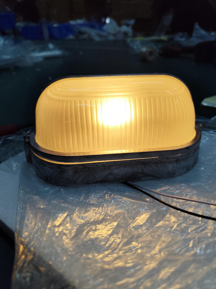 Zielona lampa zewnętrzna, design marynistyczny, metalowa, do dekoracji elewacji.
