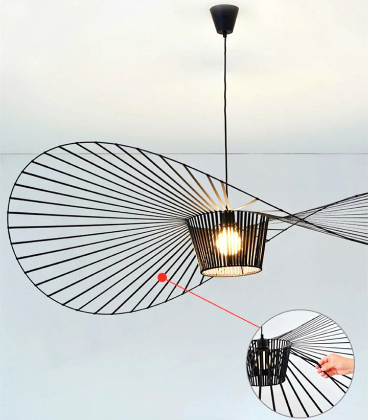 Lampa wisząca czarna, kształt kapelusza, tworząca nowoczesny akcent świetlny w salonie.