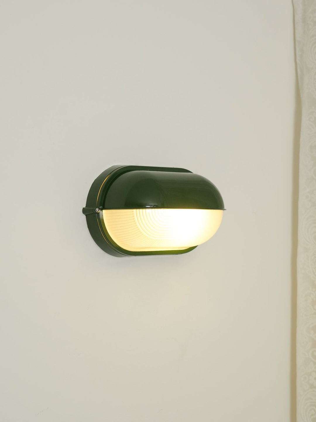 Lampa elewacyjna owalna zielona, styl przemysłowy, trwałe oświetlenie zewnętrzne.