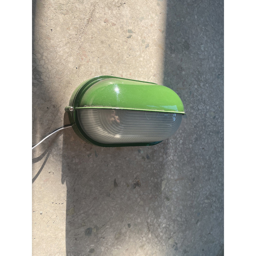 Zielona owalna lampa retro, odporna na wilgoć, do oświetlenia ściany budynku.