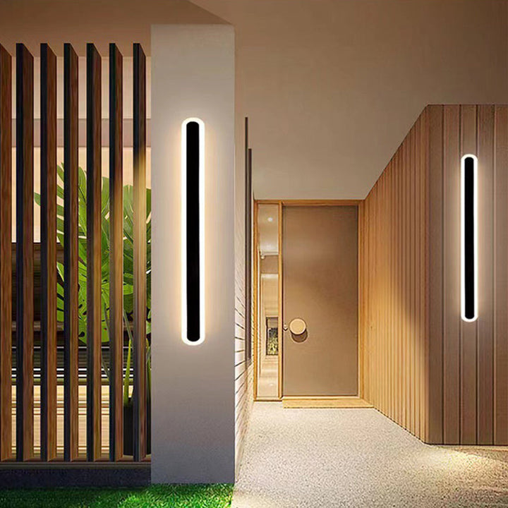 Nowoczesna czarna lampa LED zewnętrzna z czujnikiem ruchu, liniowa, ściemnialna, na elewację.