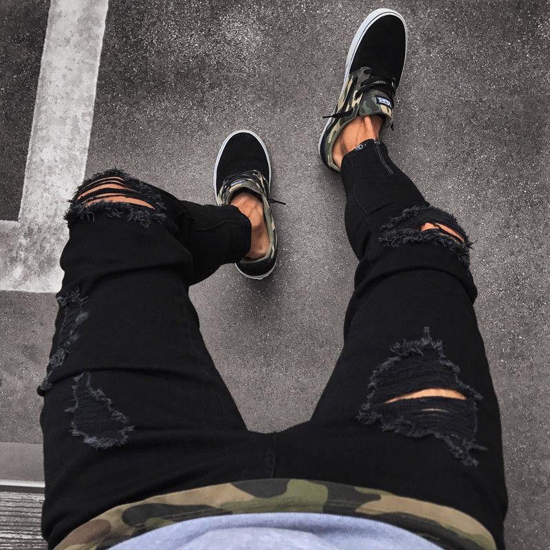Modne męskie jeansy slim fit, czarne, z designerskimi przetarciami. Doskonałe do stylu streetwear.
