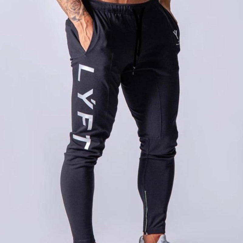 Czarne męskie spodnie dresowe z białym napisem, wygodne i modne do sportowych oraz casualowych stylizacji.