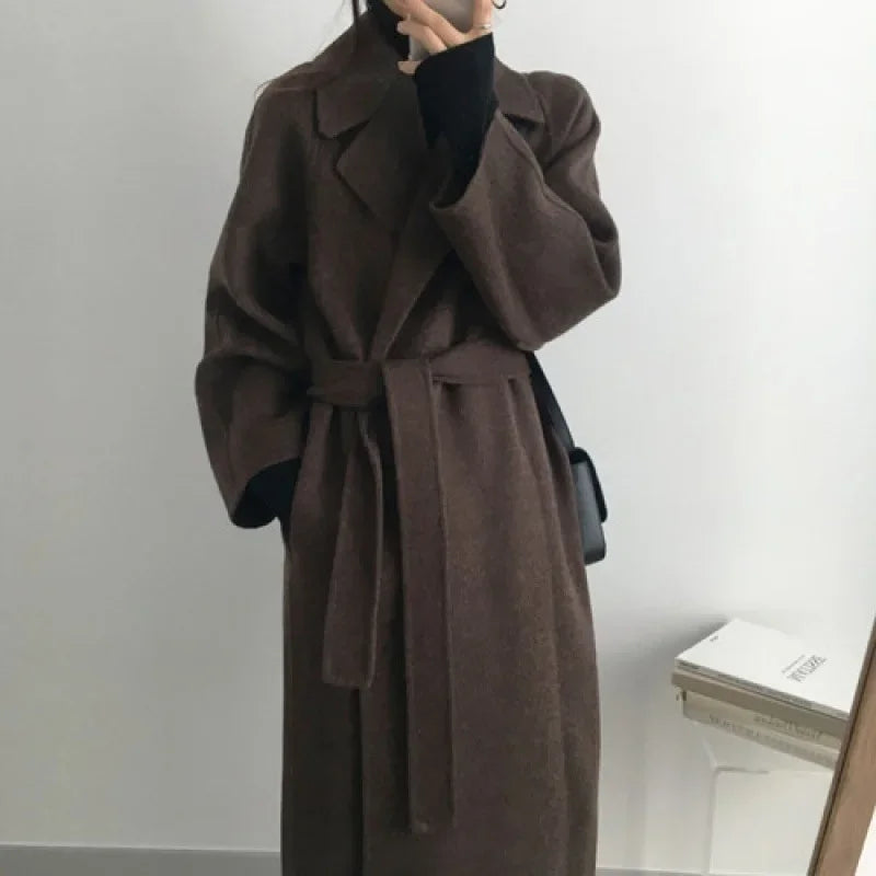 Długi płaszcz damski w jesiennej stylizacji. Elegancki i klasyczny, idealny na chłodne dni.