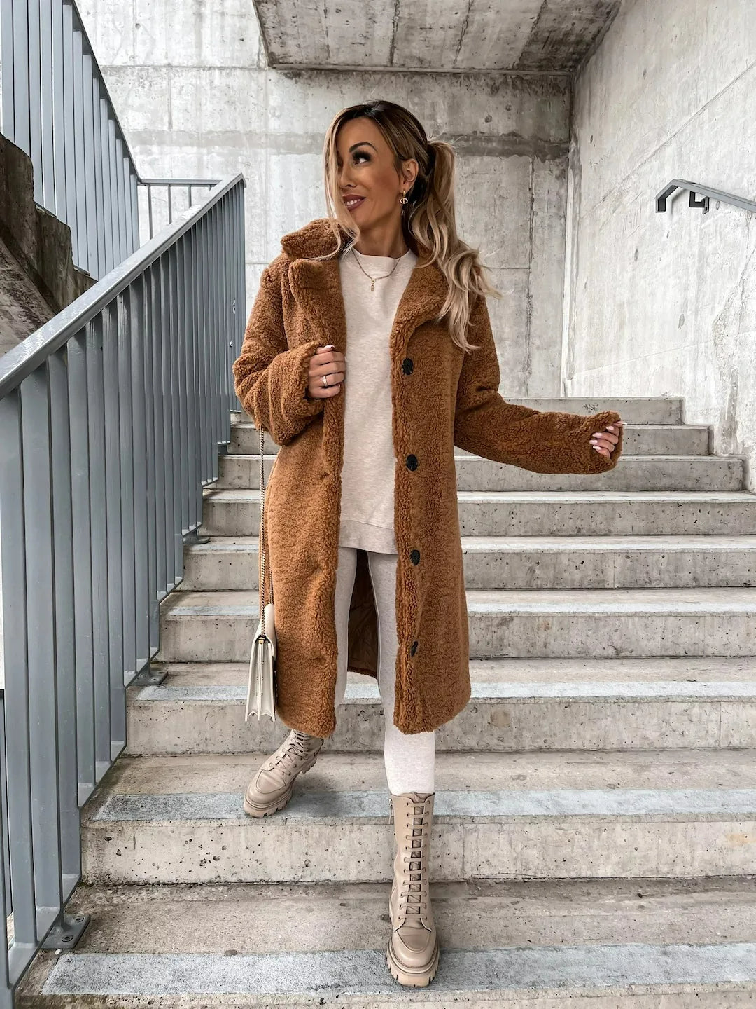 Kobieta w długim beżowym płaszczu teddy. Klasyczny krój, oversize, z guzikami. Stylowa moda damska.