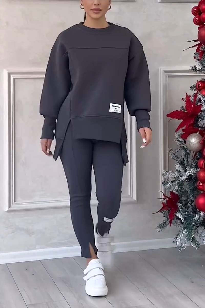 Kobieta w czarnym dresie oversize z bluzą z rozcięciami i eleganckimi legginsami