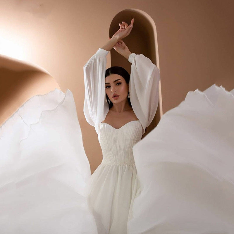 Stylowa damska sukienka maxi na wesele, biała, z długim rękawem i eleganckim dekoltem off-shoulder.