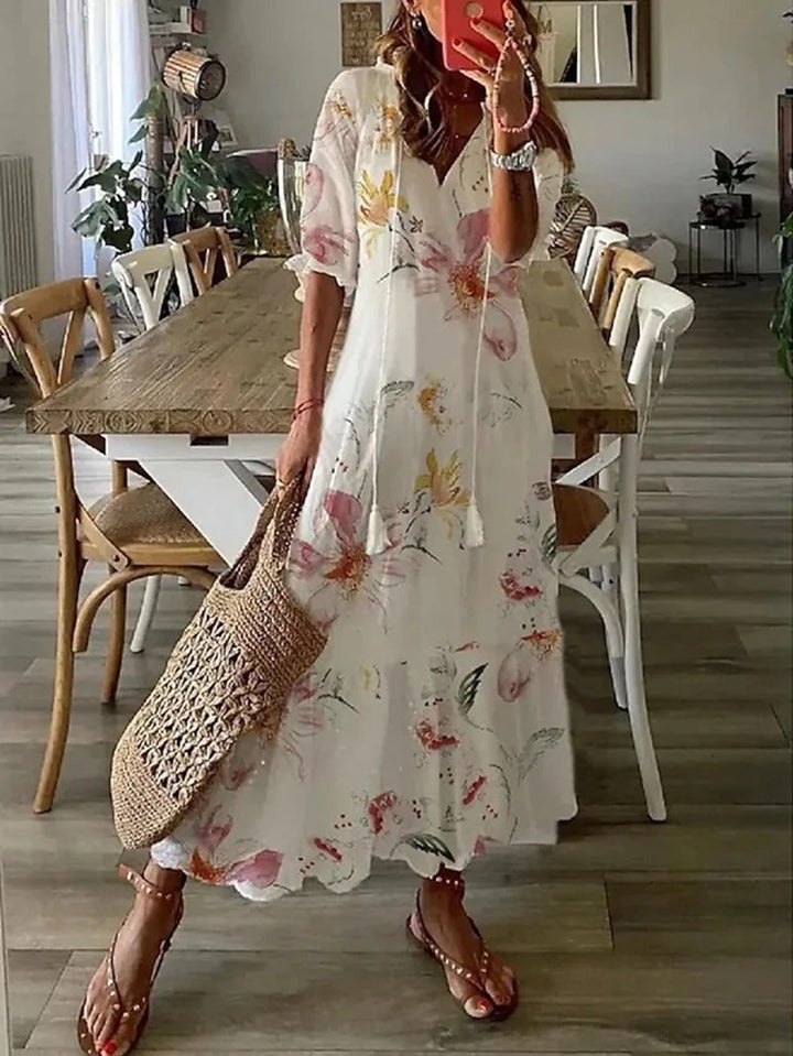 Damska sukienka maxi letnia w stylu boho z dekoltem V i kolorowym wzorem. Zwiewna i idealna na plażę.