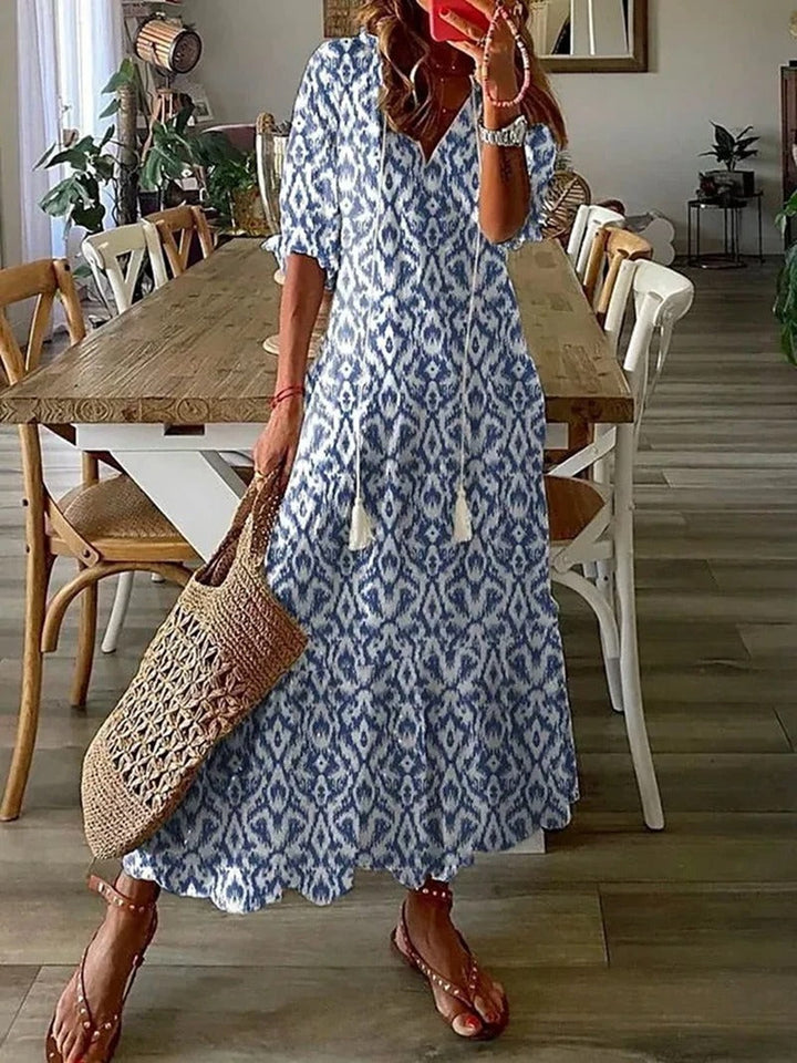 Modna sukienka letnia maxi z krótkim rękawem, dekoltem V i wyrazistym wzorem boho. Styl casual.
