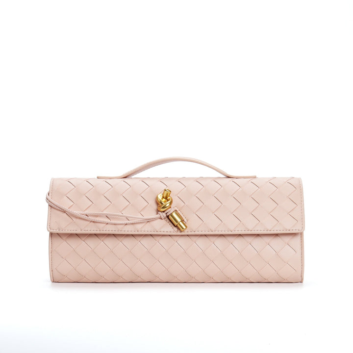 Zbliżenie na teksturę materiału eleganckiej torebki z wyjątkową klamrą na ramieniu.