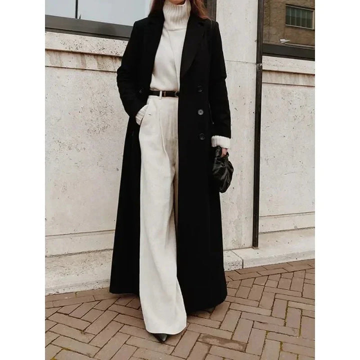 Elegancki damski płaszcz dwurzędowy w klasycznym czarnym kolorze. Długi, modny, idealny na chłodne dni jesienią i zimą.