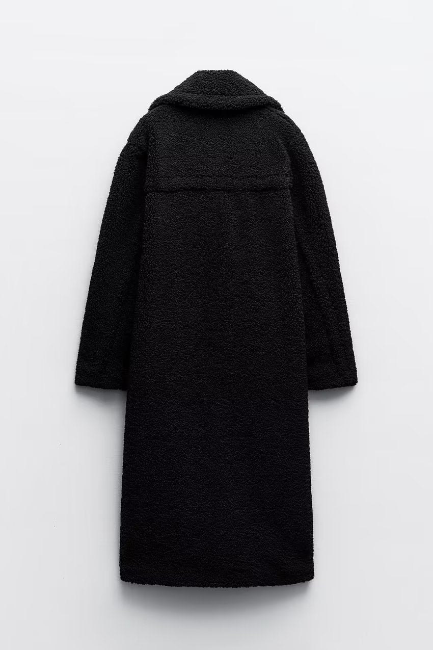 Dwurzędowy długi płaszcz damski, dostępny w beżu i czerni, luźny krój. Elegancki element garderoby.