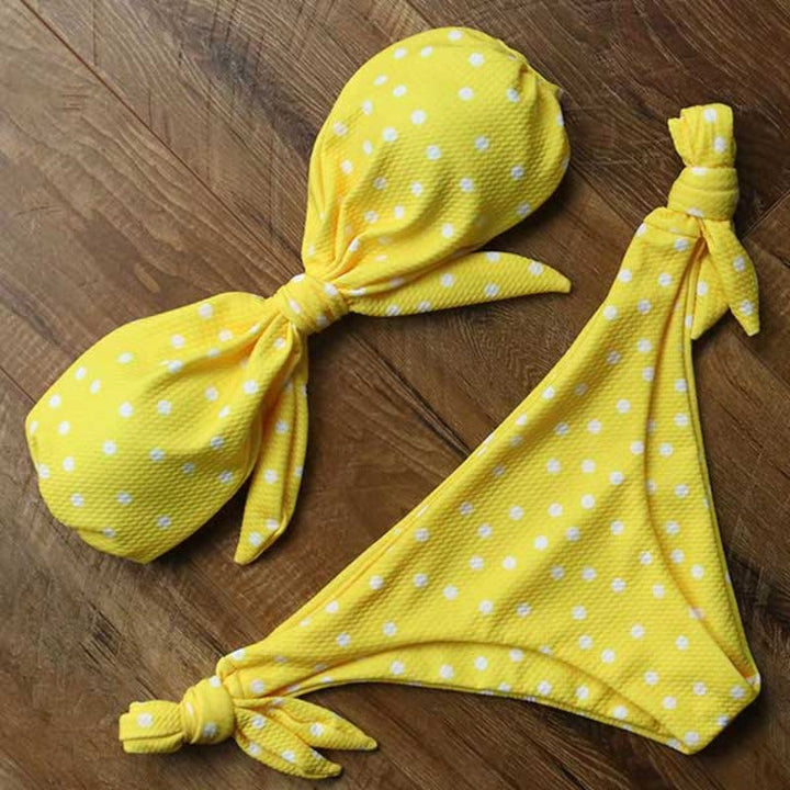 Kobieta w modnym dwuczęściowym bikini bandeau bez ramiączek na słonecznej plaży.