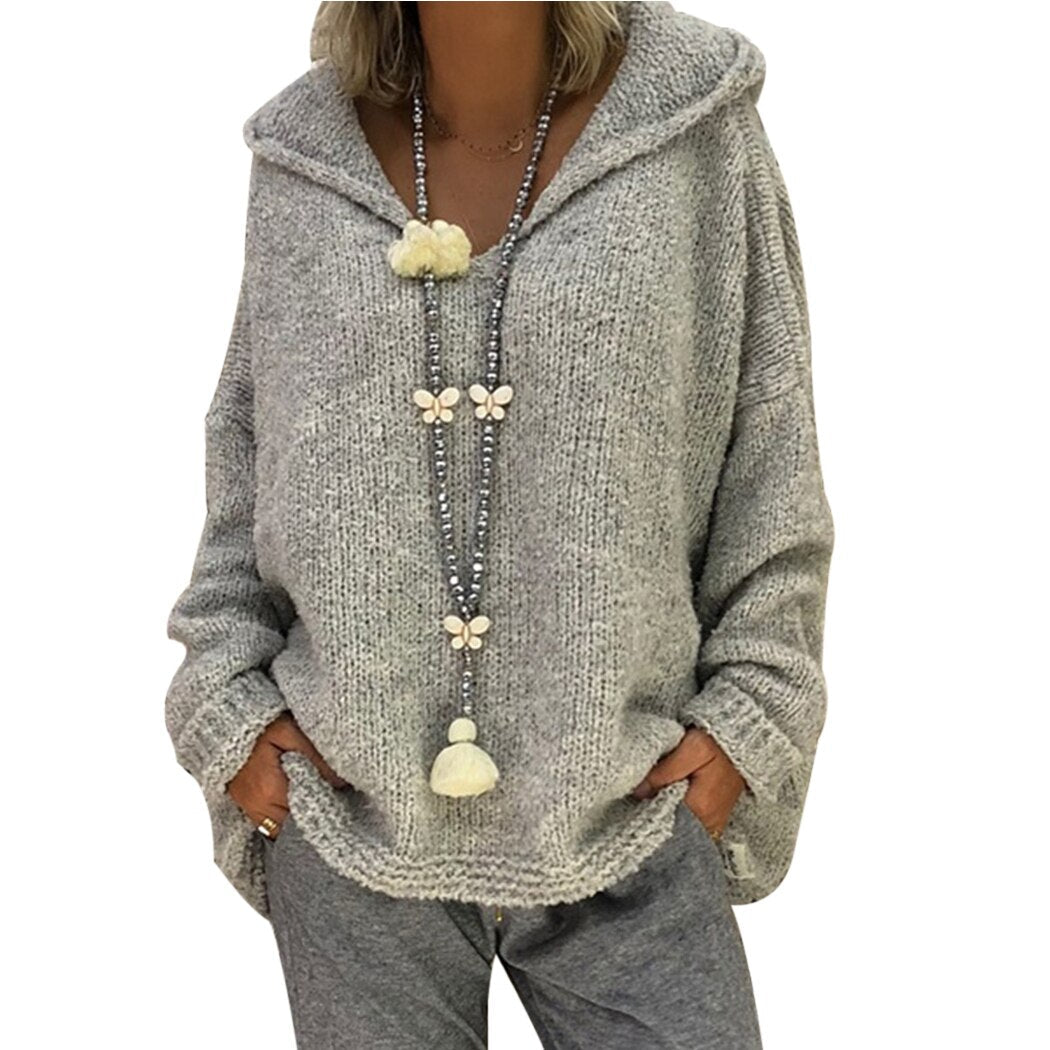 Modny damski sweter dziergany z kapturem. Casualowy, komfortowy, z dekoltem V-neck i luźnym krojem.