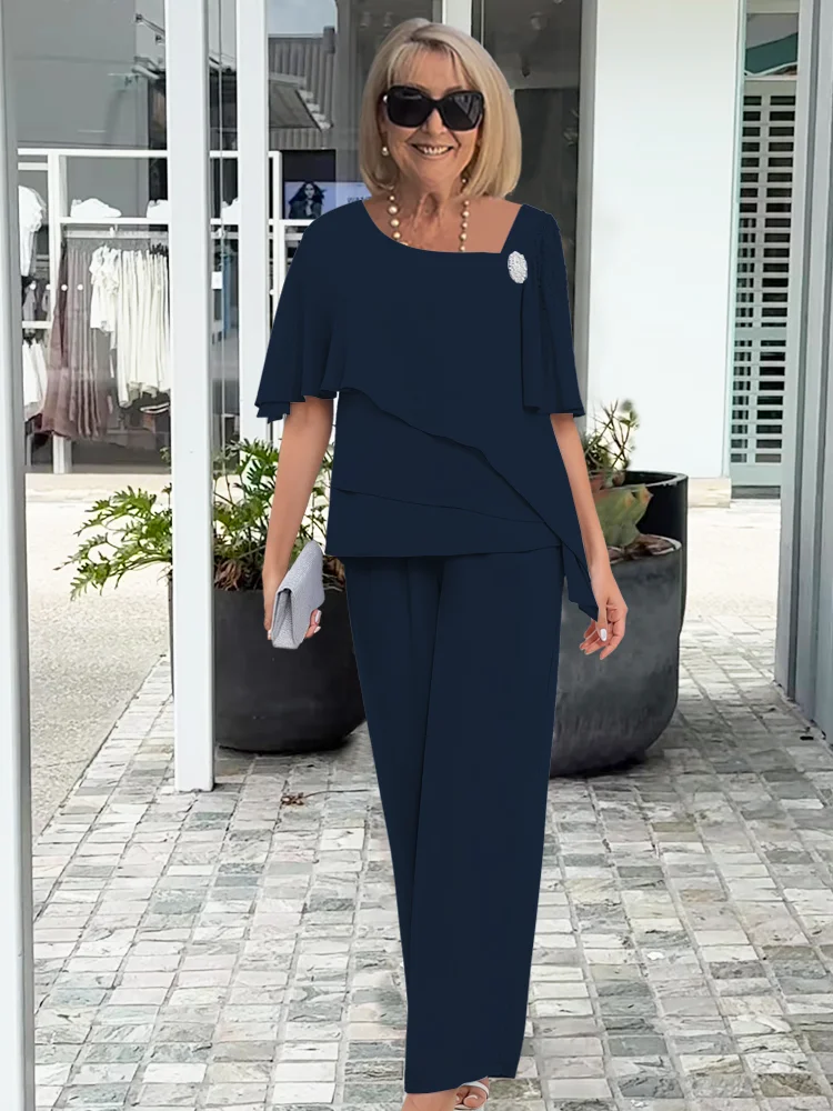 Kobieta w eleganckim granatowym garniturze z tuniką i torebką