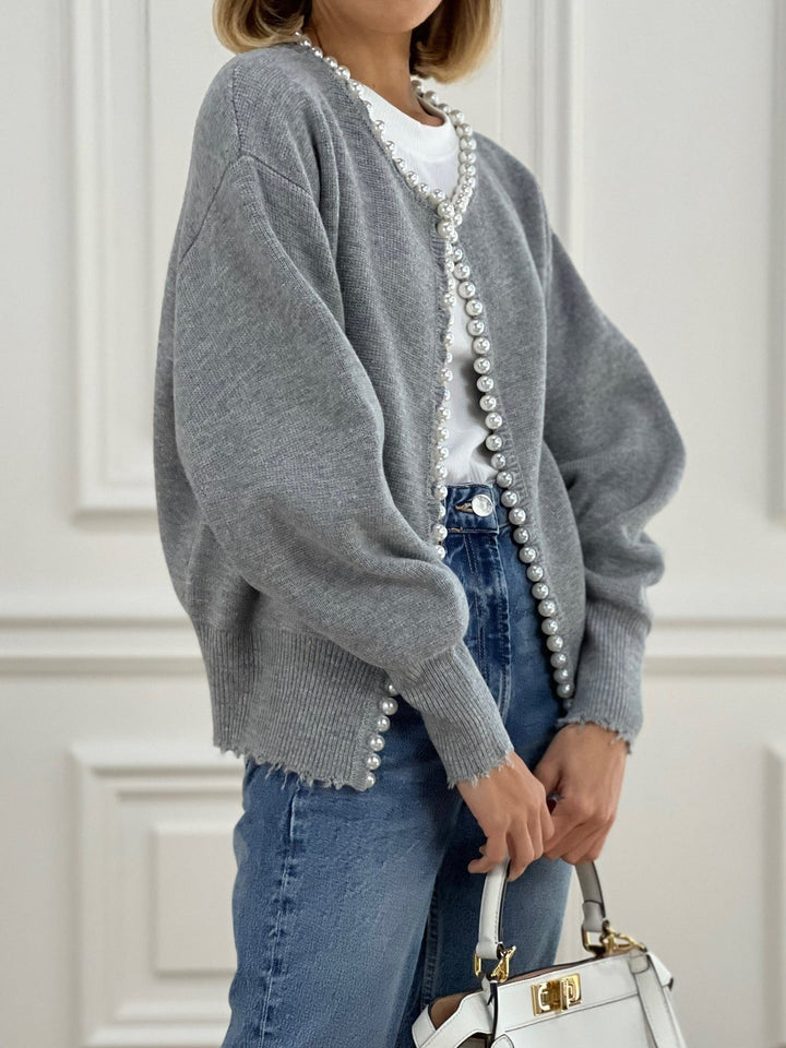 Różowy kardigan z perłowymi zdobieniami. Elegancki sweter damski z długim rękawem, idealny na każdą okazję.