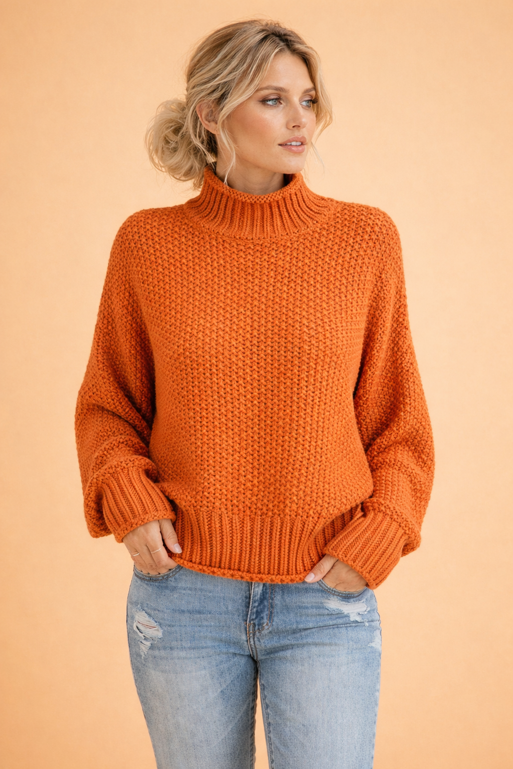 Pomarańczowy damski sweter z golfem, luźny krój, idealny na chłodne dni. Modny, oversize'owy sweter na jesień.