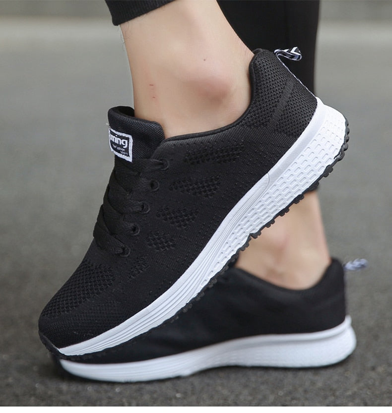 Detal logo na boku lekkich i stabilnych sneakersów damskich. Markowa jakość i styl.