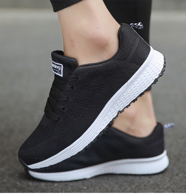 Detal logo na boku lekkich i stabilnych sneakersów damskich. Markowa jakość i styl.