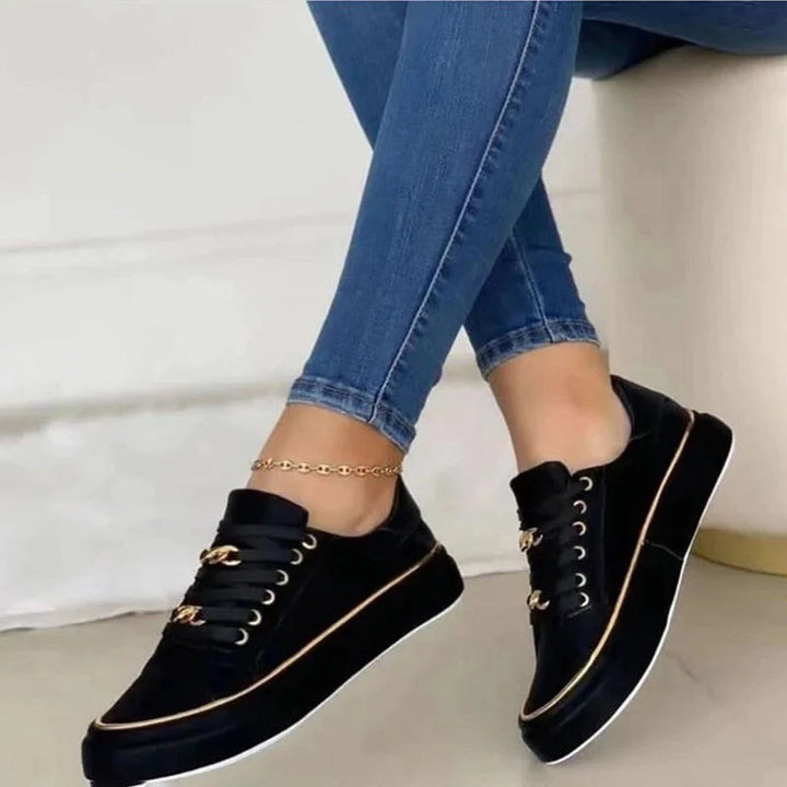 Modne damskie sneakersy z łańcuszkiem i złotymi akcentami. Idealne na jesień i zimę, stylowy miejski look.