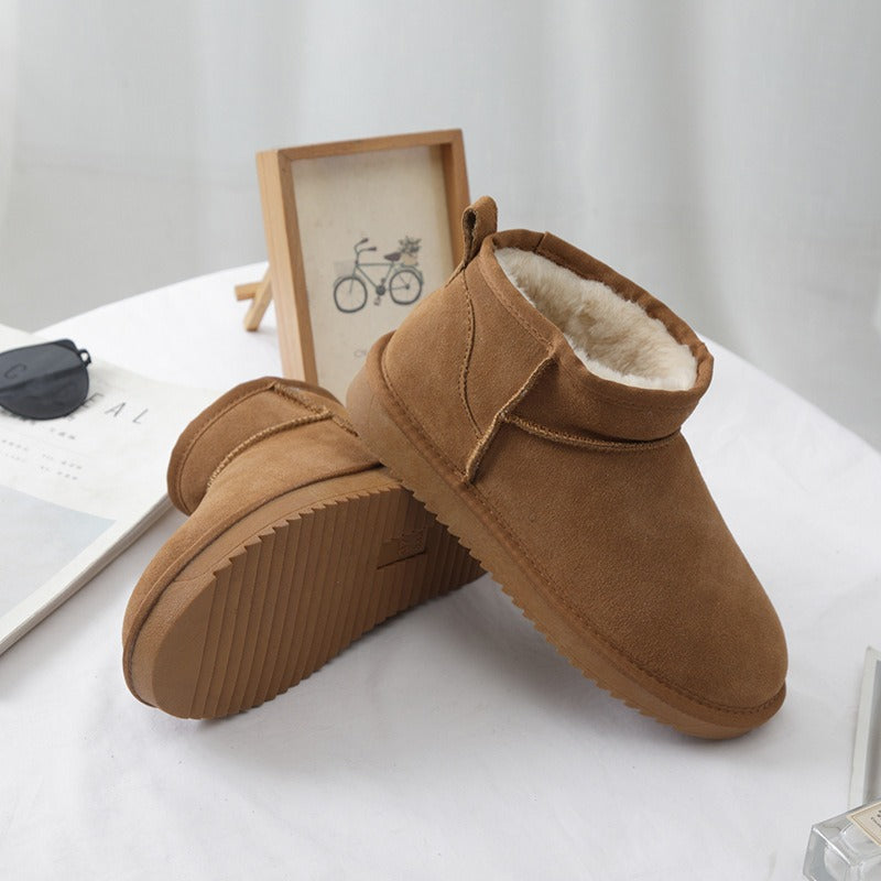 Karmelowe damskie buty zimowe prezentowane na stole z dekoracjami