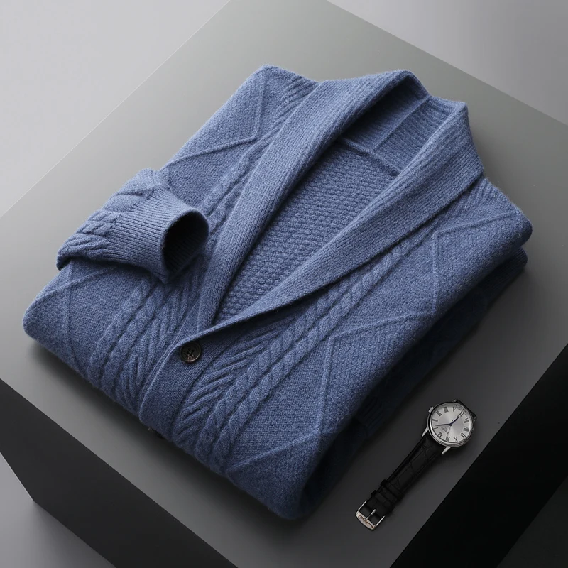 Złożony niebieski męski sweter rozpinany z plecionym wzorem obok eleganckiego zegarka