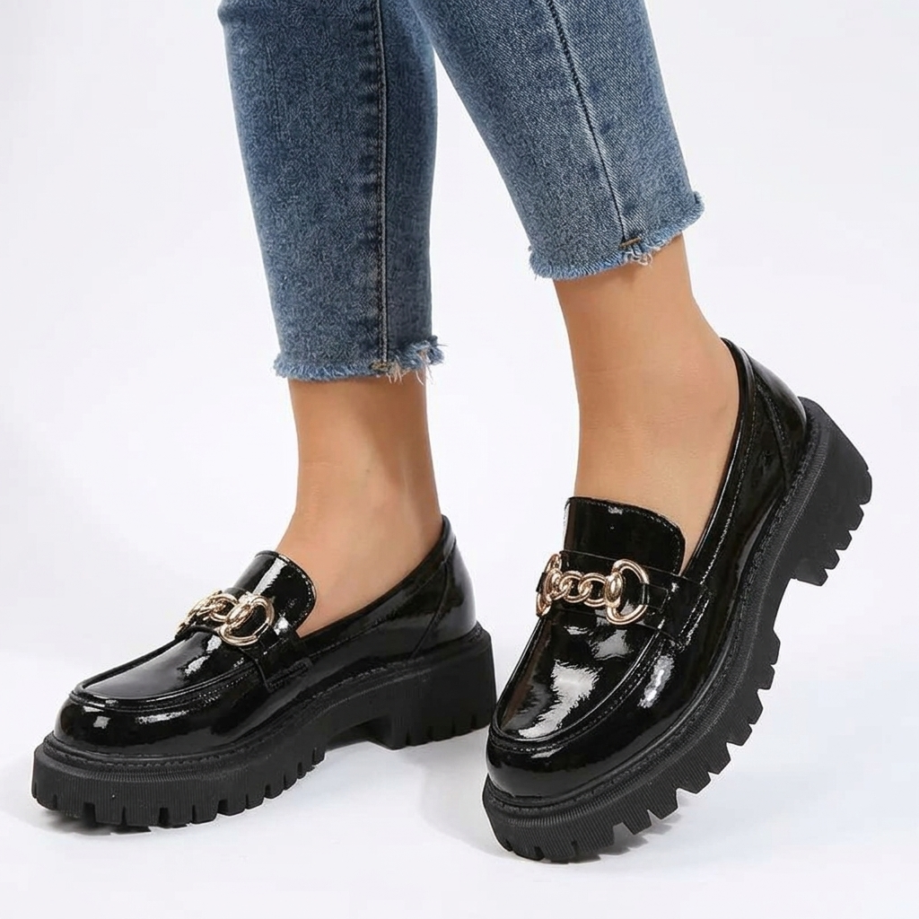 Kobieta w jeansach prezentująca czarne loafersy chunky z ozdobnym łańcuszkiem