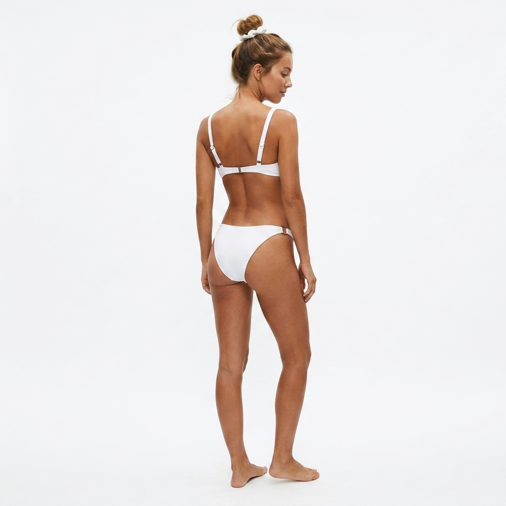 Widok z tyłu na modelkę w białym bikini plażowym z ozdobnymi kółkami