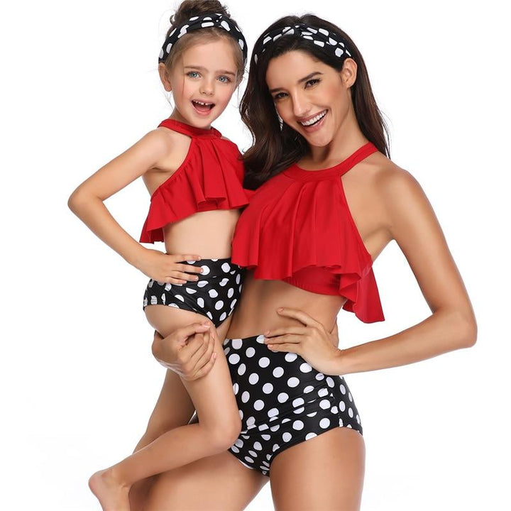 Szczęśliwe mama i córka w matchingowych strojach kąpielowych bawią się na plaży. Letnie bikini.