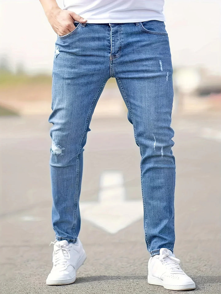 Mężczyzna w niebieskich męskich jeansach slim fit stojący na ulicy