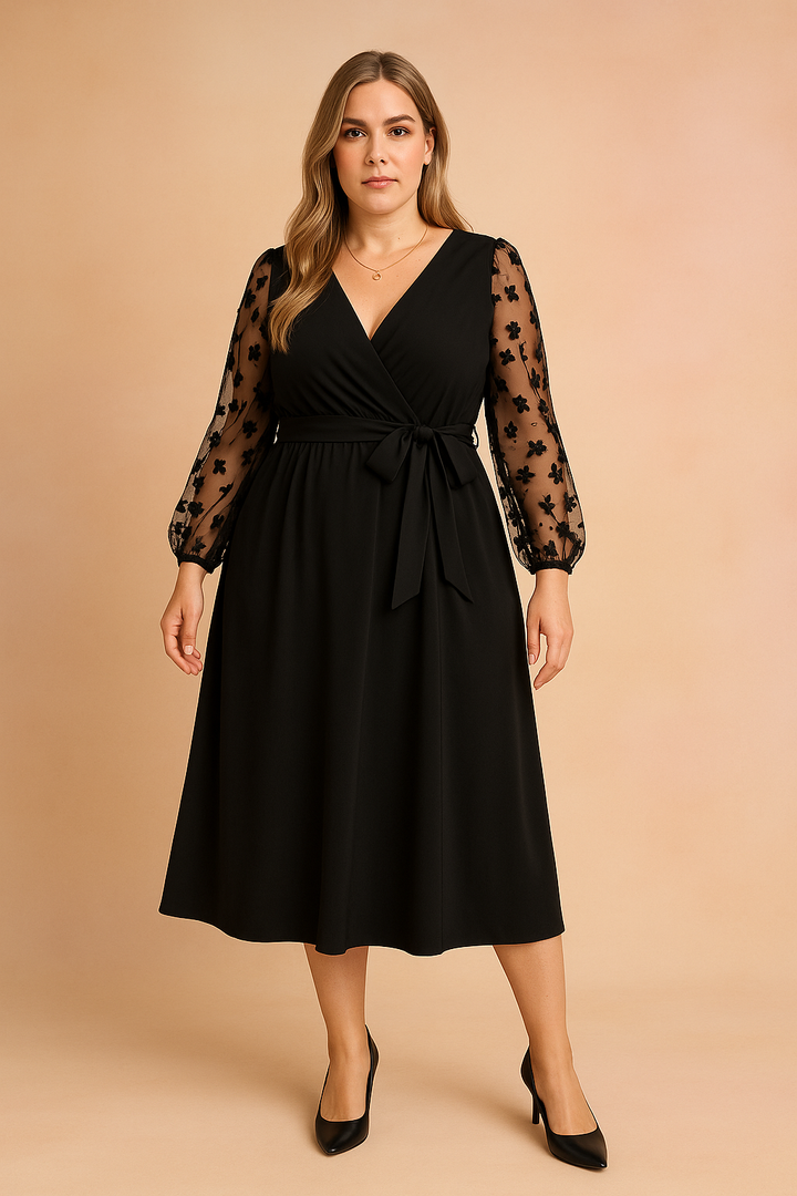 Modna czarna sukienka wieczorowa midi plus size. Elegancki fason kopertowy z delikatnymi, tiulowymi rękawami.
