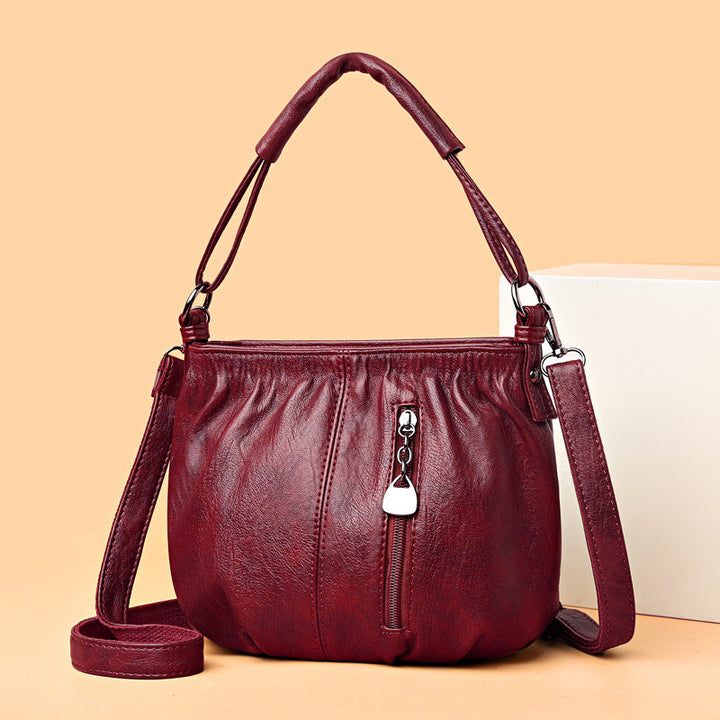 Kobieta nosząca elegancką torebkę skórzaną Iris. Modne akcesorium damskie, idealne do jesiennych stylizacji.