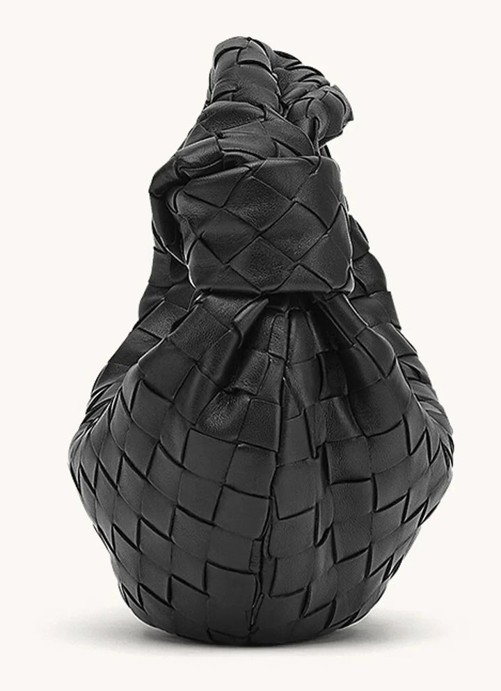 Kobieta z elegancką torebką damską na ramieniu, prezentująca modny styl. Podręczna.
