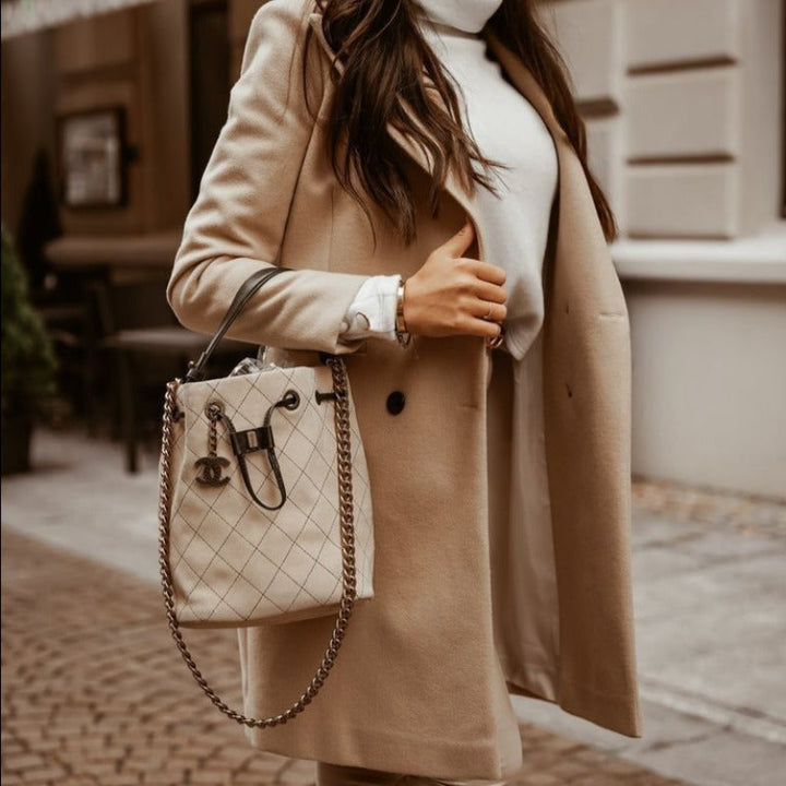 Czarny płaszcz damski przejściowy na guziki, z praktycznymi kieszeniami. Elegancka moda jesienno-wiosenna.