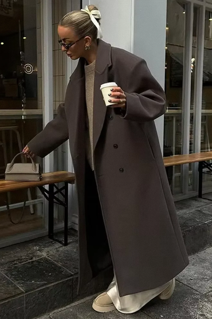 Elegancki brązowy damski długi płaszcz dwurzędowy, idealny na zimową stylizację.